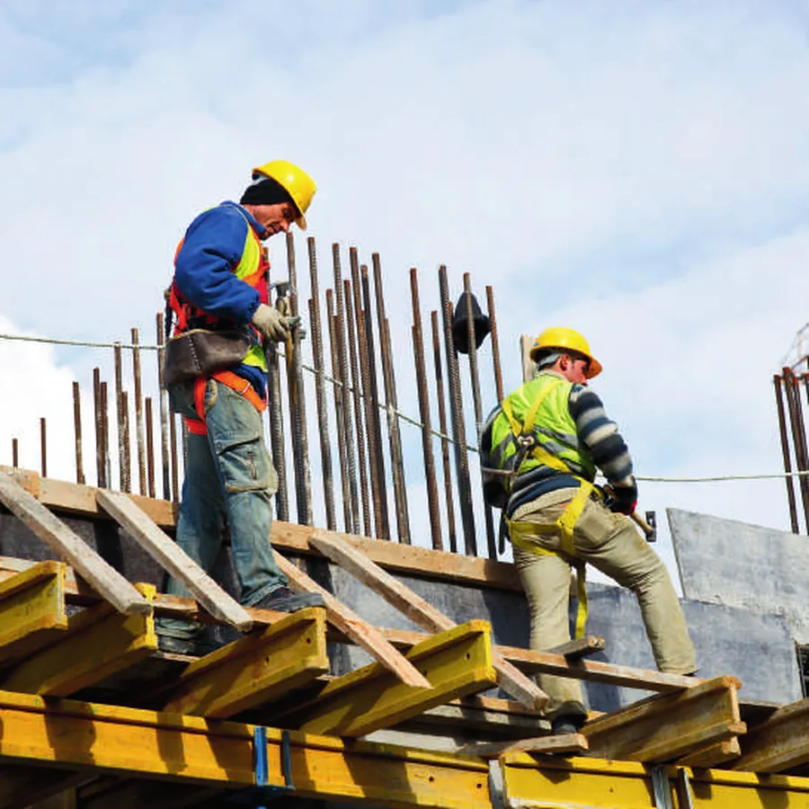 Construction workers fixing steel reinforcement on a building site
